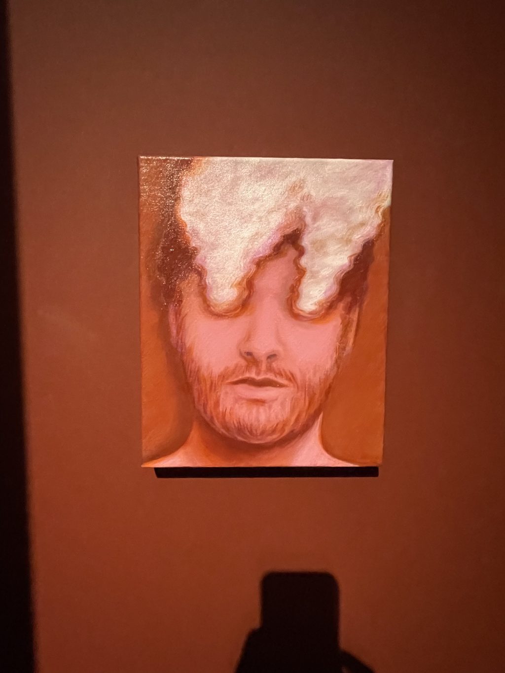 Gemälde in Rottönen zeigt das Gesicht jungne Mannes, aus dessen Augen Rauchwolken aufsteigen