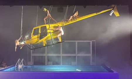 Vier nackte Frauen auf gelbem Hubschrauber